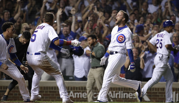 Chicago Cubs' David Bote, right, reacts as he celebrates with teammates after hitting the game-winning grand slam during the ninth inning of a baseball game against the Washington Nationals.