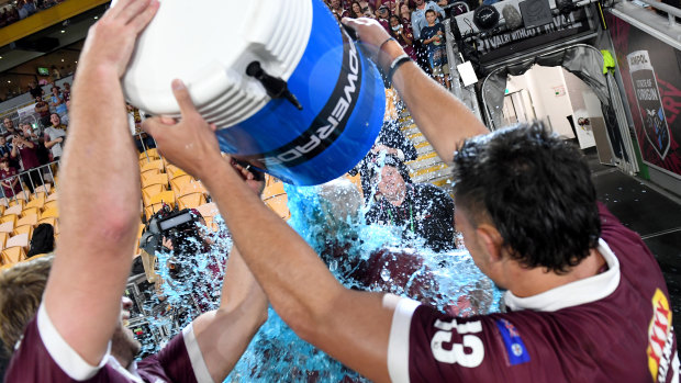 Maroons coach Wayne Bennett has an ice bucket poured on him by Tino Fa'asuamaleaui and Christian Welch.