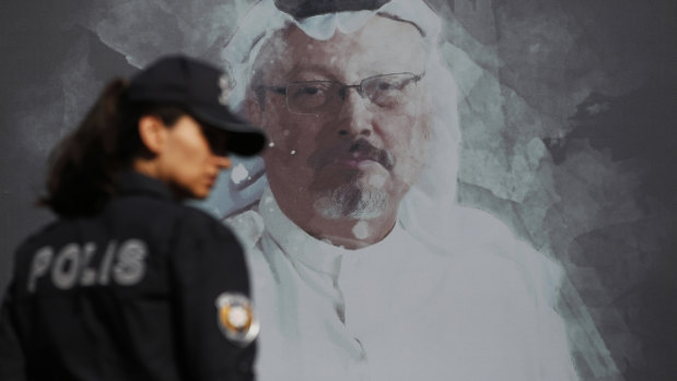 A Turkish police officer walks past a picture of slain Saudi journalist Jamal Khashoggi before a ceremony, near the Saudi Arabia consulate in Istanbul, marking the one-year anniversary of his death.