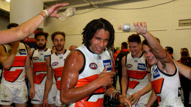 Aiden Bonar gets the obligatory drenching after his AFL debut for the Giants.