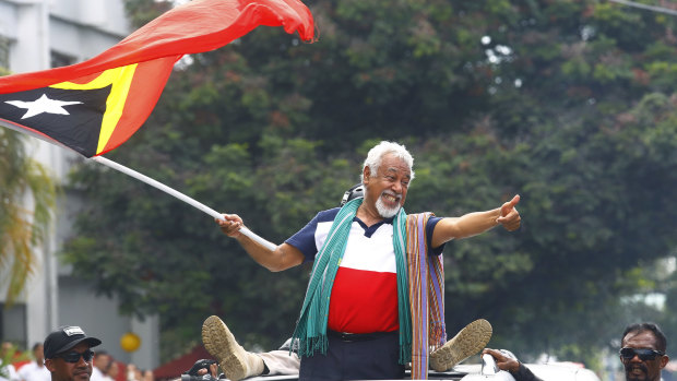 East Timorese independence hero Xanana Gusmao waves a national flag at a pre-election rally.