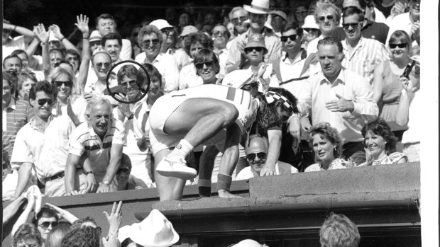 Pat Cash scales the Wimbledon wall after winning in 1987, with Jeff Bond (circled) in his players box.