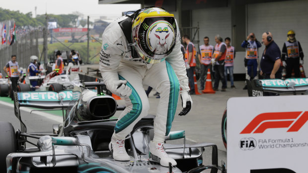 Hamilton, with his special helmet design, celebrating his pole position.