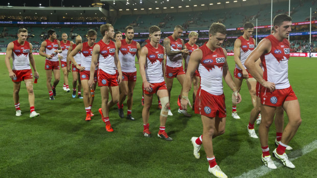Dejected: the Swans trudge off the SCG after the loss to Adelaide.