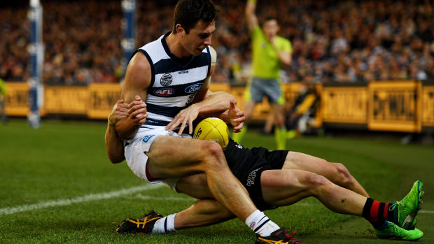 No prisoners: Geelong's Jack Henry gets taken down across the boundary line.