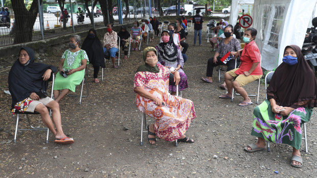 Jakarta residents practice social distancing as they queue for free rice provided by the government for those whose livelihoods are affected by the coronavirus outbreak.