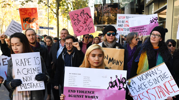 Protesters hold placards as they march through Melbourne to protest violence against women.