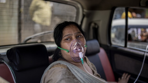 A COVID-19 patient sits inside a car and breathes with the help of oxygen provided by a Gurdwara, a Sikh house of worship, in Delhi, India.