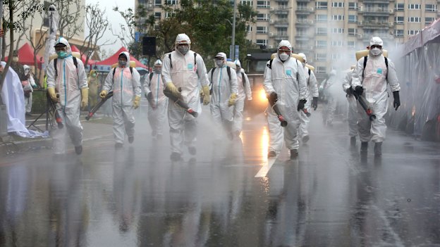In Taiwan, soliders spray disinfectant in a drill for coping with cluster infections.