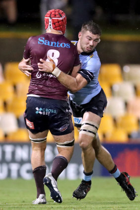 Harry Wilson of the Reds is tackled by Max Douglas of the Waratahs.