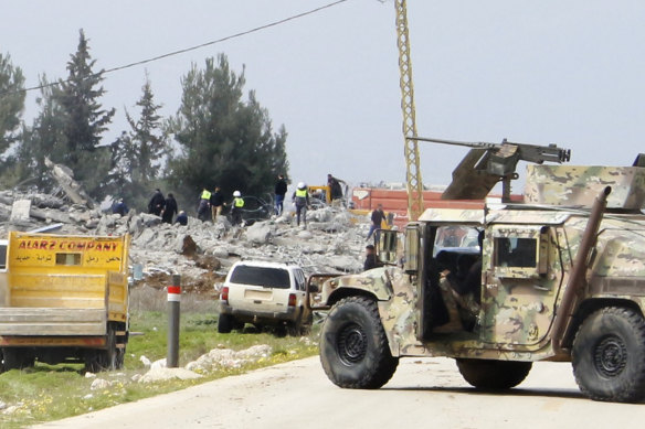 A Lebanese army vehicle block a road leading to a destroyed warehouse, background, which was attacked by Israeli airstrikes, on the outskirts of the Hezbollah stronghold village of Buday, near Baalbek town, east Lebanon, Monday.
