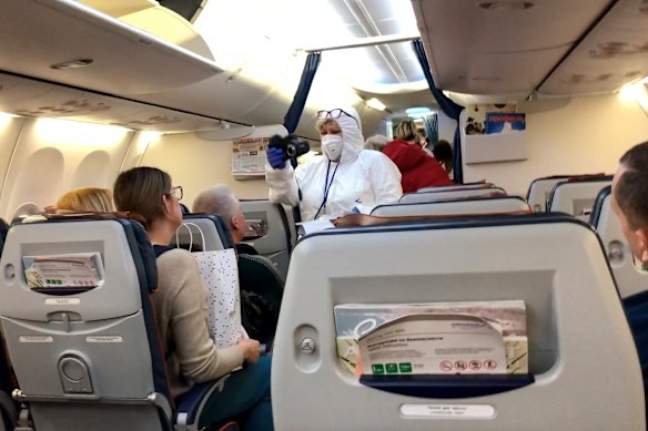 A Russian medic checks the temperature of passengers arriving from Italy on a plane at Sheremetyevo airport outside Moscow.