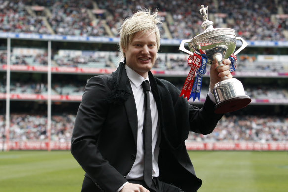 Collingwood fan Neil Robertson is driven around the MCG with his World Snooker Championship trophy in 2010.