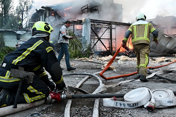 Firefighters work near the scene of a fire after a jet-powered drone struck an office building in Kyiv’s Podilskyi district, on Friday (Ukrainian time).