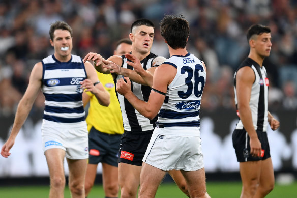 Brayden Maynard of the Magpies pushes Oliver Henry of the Cats.