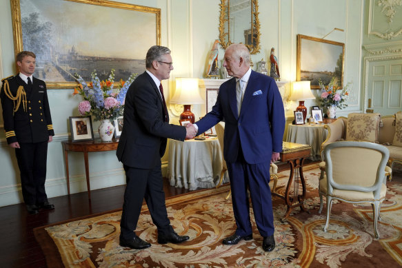 King Charles III, right, shakes hands with new British Prime Minister Sir Keir Starmer as the pair meet at Buckingham Palace.