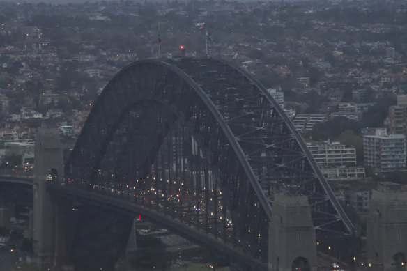 The Sydney Harbour Bridge’s flags at half-mast just after 6am.