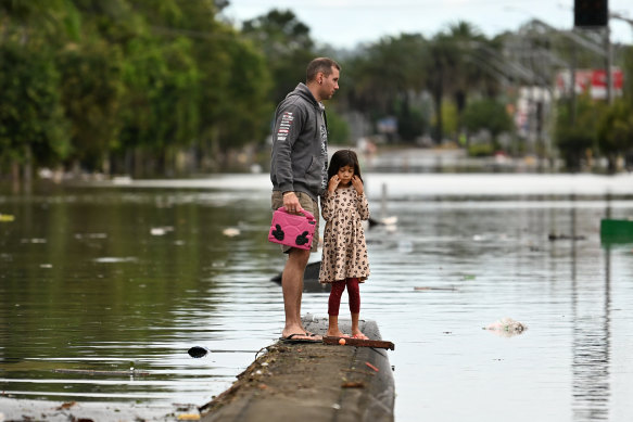Father and daughter survey the flood damage in Lismore earlier this year.