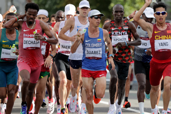 Runners take water at the refreshment point while competing in the men’s marathon in Sapporo, Japan, on Sunday.