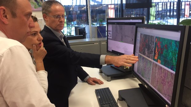 Queensland government principal scientist David Harris shows Deputy Premier Jackie Trad and Environment Minister Steven Miles the latest satellite imagery of tree clearing.