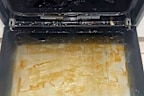 Dirty oven glass door from roast marinade and grease.