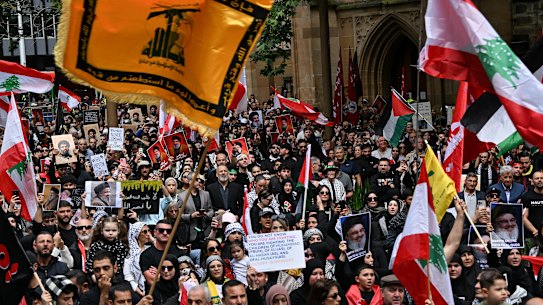 Demonstrators hold Hezbollah flags and pictures of Hassan Nasrallah, the late leader of the Lebanese militant group, at a rally in Sydney. This masthead does not suggest that any person pictured will or should be charged.