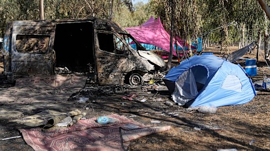 Tents, debris and a burned out van are scattered about the site of a music festival near the border with the Gaza Strip days after October 7.