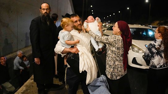 Israeli families take cover on the side of a freeway from Iranian missile strikes.