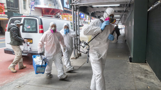 Men in protective gear arrive to disinfect a construction site in New York last month.