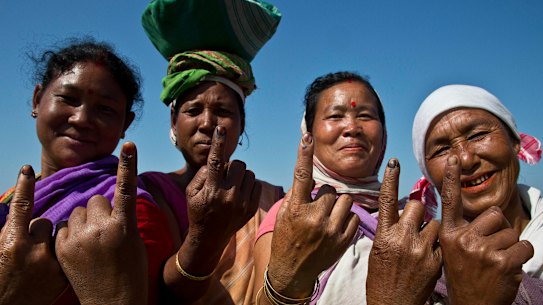 Indian Mishing tribal women show the indelible ink marks on their index fingers after casting their votes.