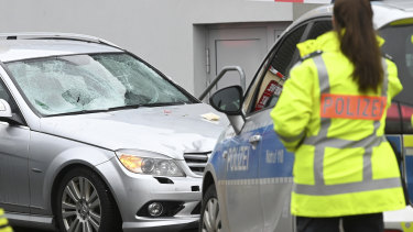 Police stand next to the scene of the accident with the car that is said to have crashed into a carnival parade in Volkmarsen, central Germany.