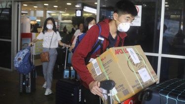 People arriving at Sydney Airport wearing masks.