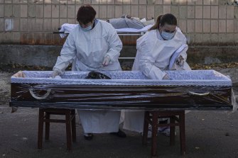 Medical staff prepare a coffin for a body of a patient who died of coronavirus at the morgue of the city hospital 1 in Rivne, Ukraine.