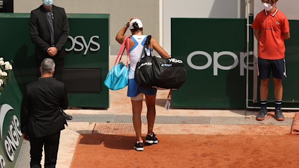 A dejected Ash Barty leaves the court after retiring hurt during her second round match at Roland-Garros.