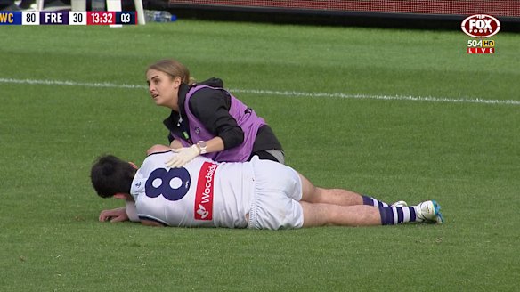 Andrew Brayshaw on the Optus Stadium turf after the hit.