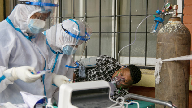 Nepalese paramedics treat a COVID-19 patient outside an emergency ward of a government run hospital in Kathmandu.