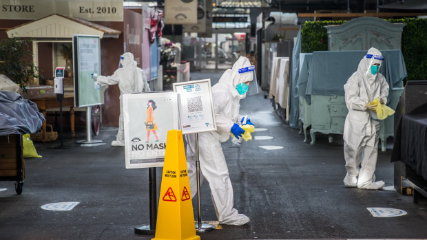 People in hazmat suits give Prahran Market a deep clean on Thursday.