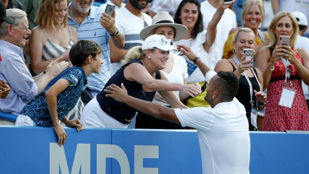 Sharing the love: Kyrgios enjoys the moment with a member of the crowd after his win, in a new trademark for the Australian.