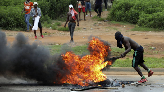 A man stands by a bonfire during a protest opposite a South African-owned  Shoprite in Abuja, Nigeria, on Wednesday. 