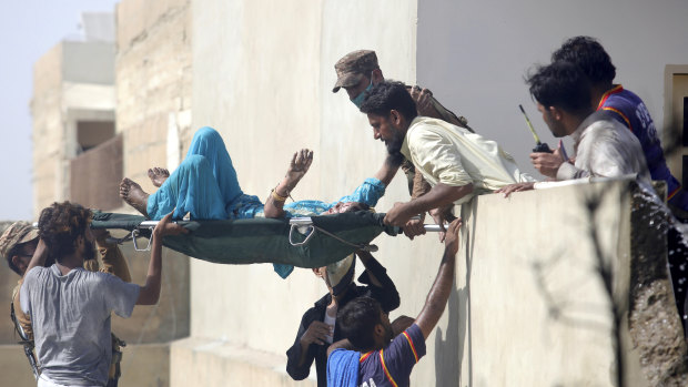 An injured woman is carried away from the site of the crash.