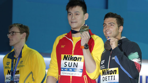 China's Sun Yang, centre, holds up his gold medal with silver medallist Australia's Mack Horton, left.