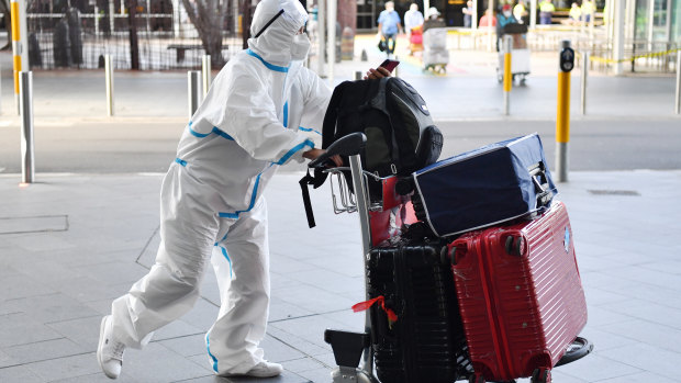 An international traveller dressed in protective clothing arrives at Sydney  Airport on Friday. 