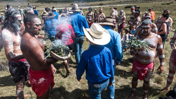 Pro-brumby activists go through the smoke at the ceremony, held on March 6.