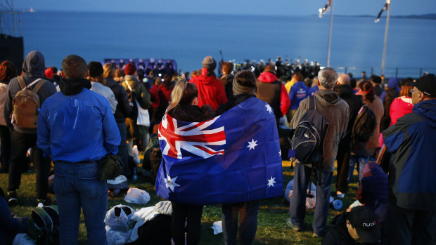 A pair draped with an Australian flag, participate in the Dawn Service ceremony at the Anzac Cove beach in Gallipoli, Turkey. 