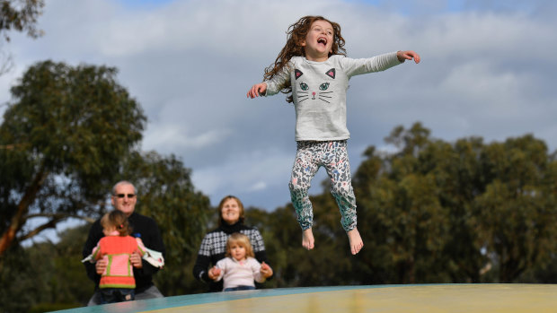 No queueing for the playground: Mia Elliott, 6,  bounces on a giant pillow at Anglesea Family Caravan Park as parents Troy and Cheryl and twin sisters Hayley and Chloe, two, look on.