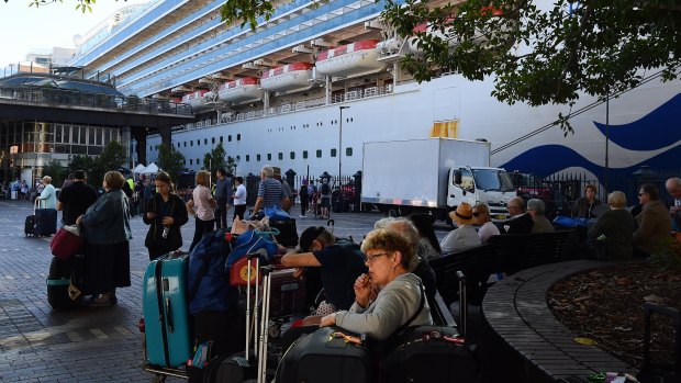 Ruby Princess passengers sit in Circular Quay after disembarking the ship on March 19.