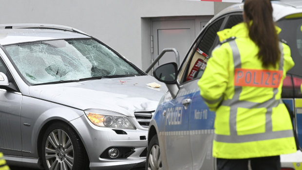 Police stand next to the scene of the accident with the car that is said to have crashed into a carnival parade in Volkmarsen, central Germany.