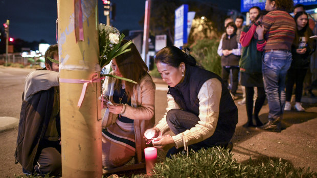Aivy Nguyen's grieving family light candles.