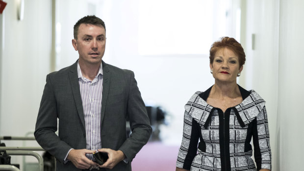 Senator Pauline Hanson and her adviser, James Ashby, walk to a TV interview at Parliament House in Canberra.