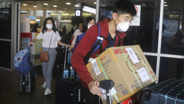 People arriving at Sydney Airport wearing masks.